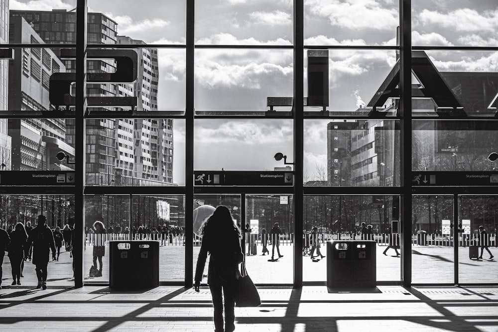 silhouette of woman walking on sidewalk during daytime