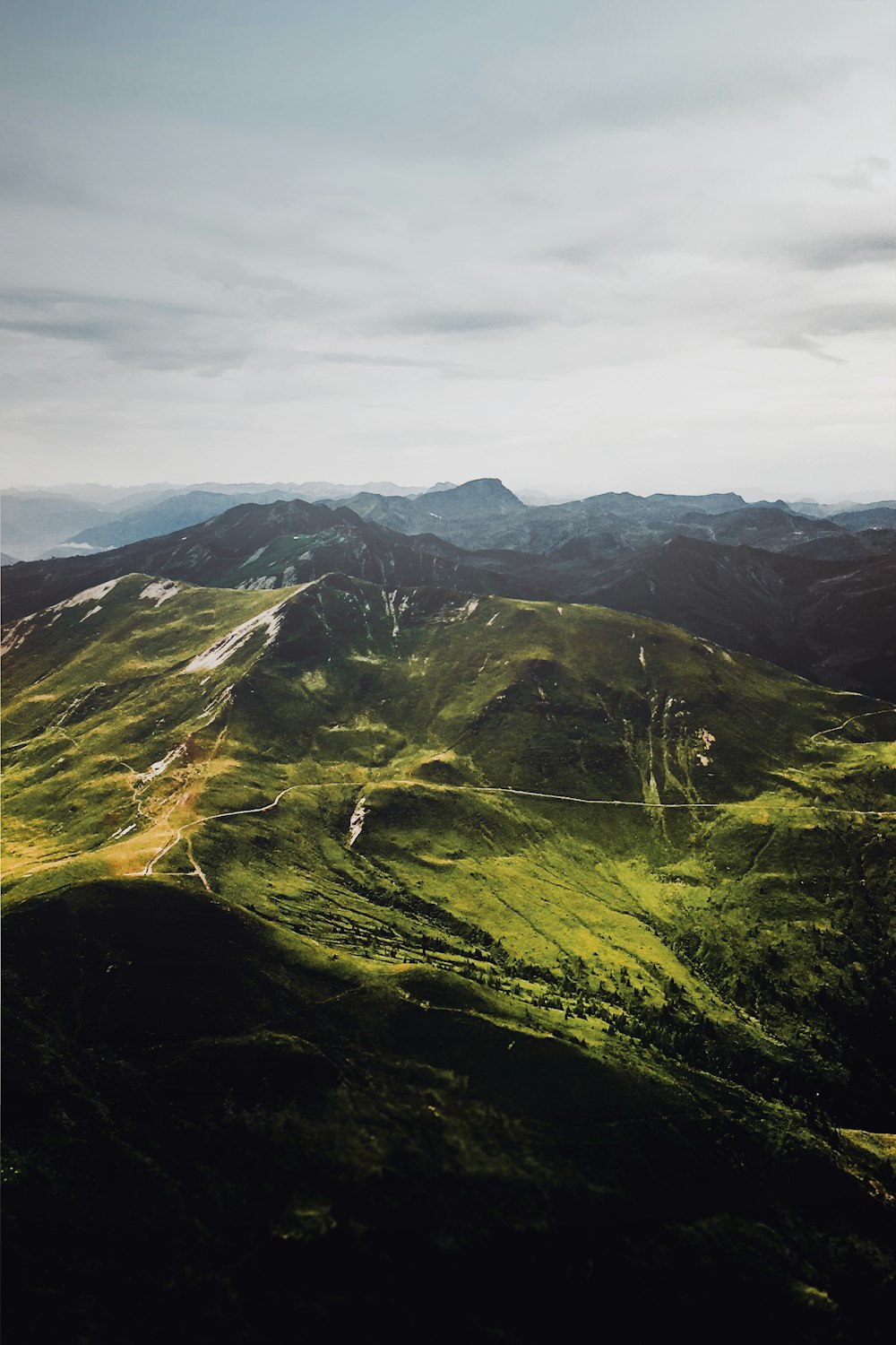 montagnes vertes et brunes sous des nuages blancs pendant la journée