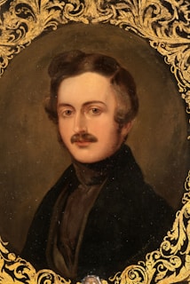 A timeless, dark academia style image of Rudolf Steiner, framed by intricate geometric patterns in gold.