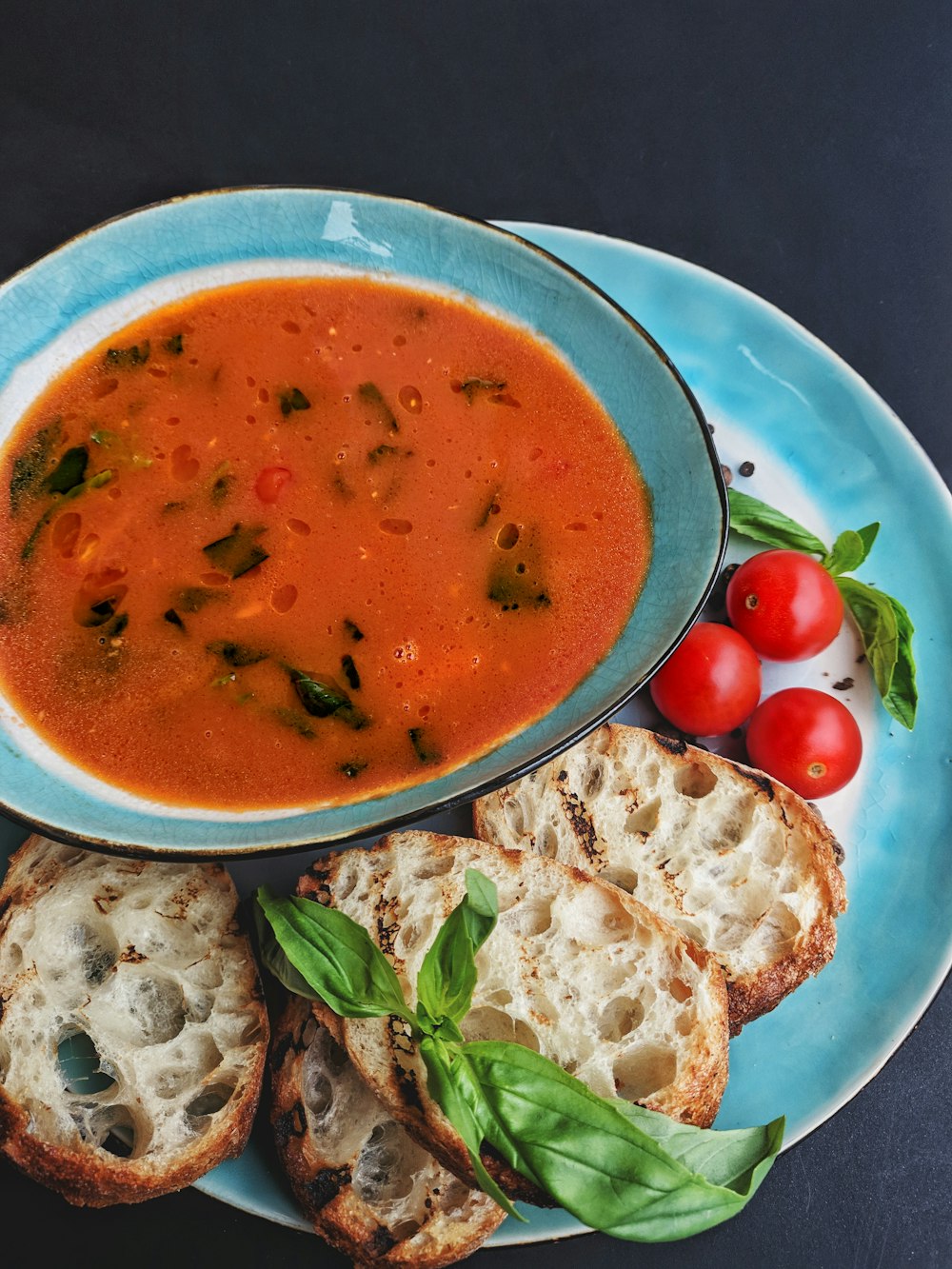 soup with sliced of vegetables on blue ceramic bowl