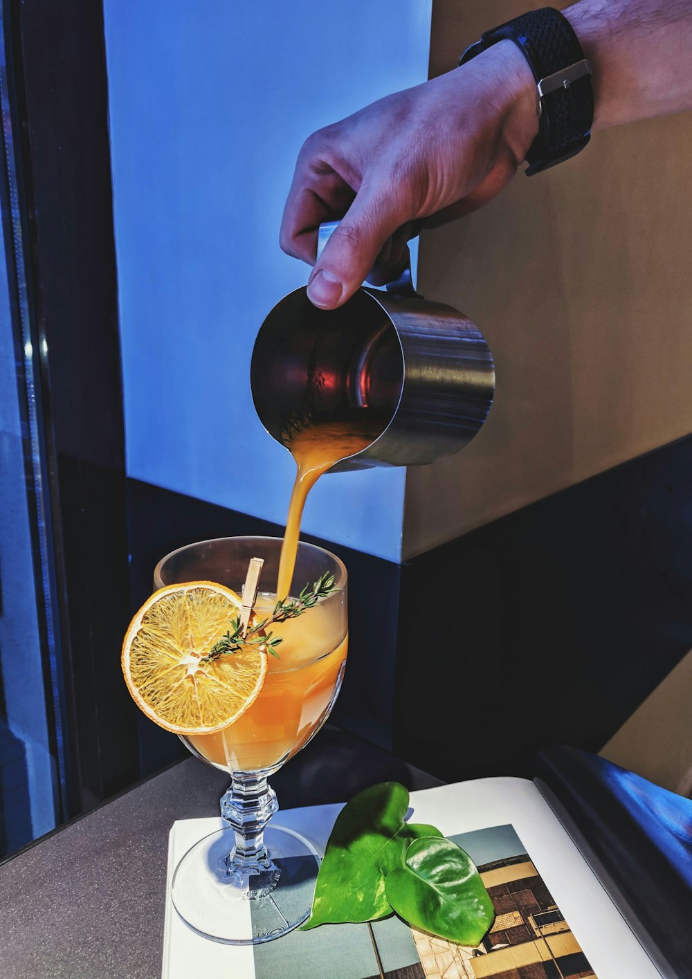 person holding stainless steel cup with yellow liquid