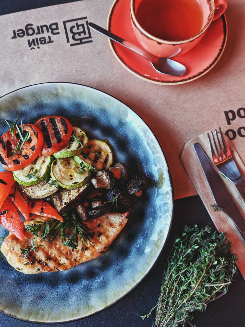 pizza with green vegetable and tomato on blue ceramic plate