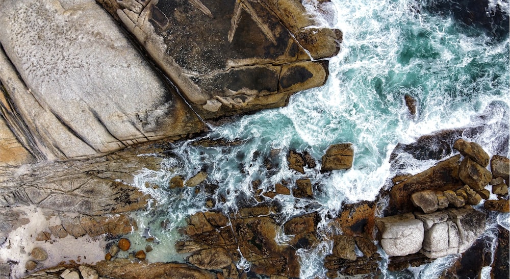 brown rock formation on body of water during daytime