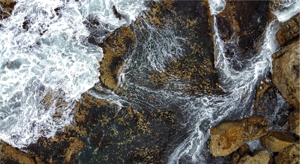 black and brown rock formation near body of water during daytime