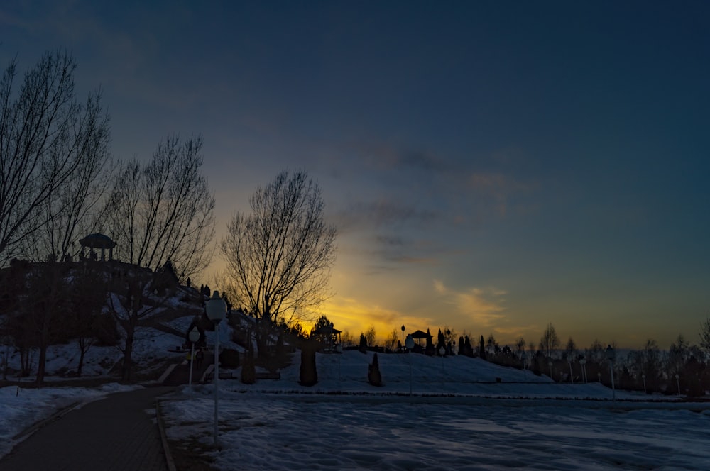 people on snow covered field during sunset