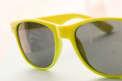 Close-up of a sleek, minimalist sunglasses frame with vibrant accent colors on a neutral background.