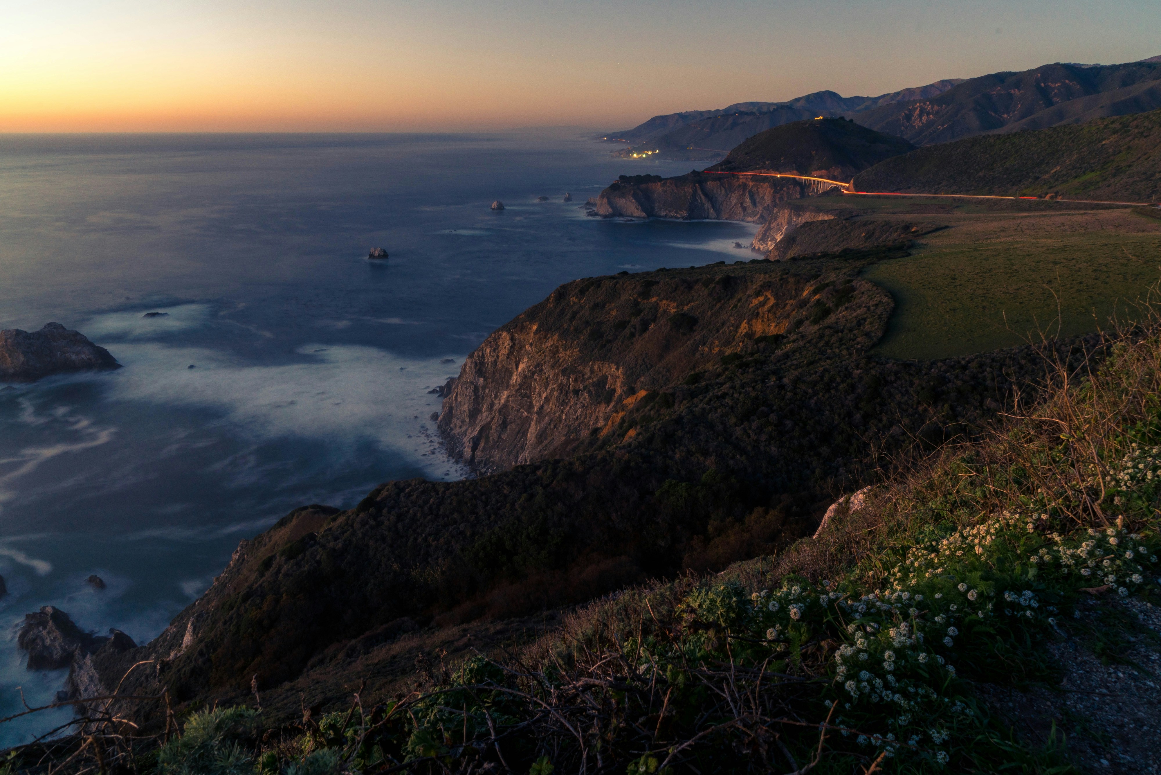 brown and green mountain beside body of water during daytime