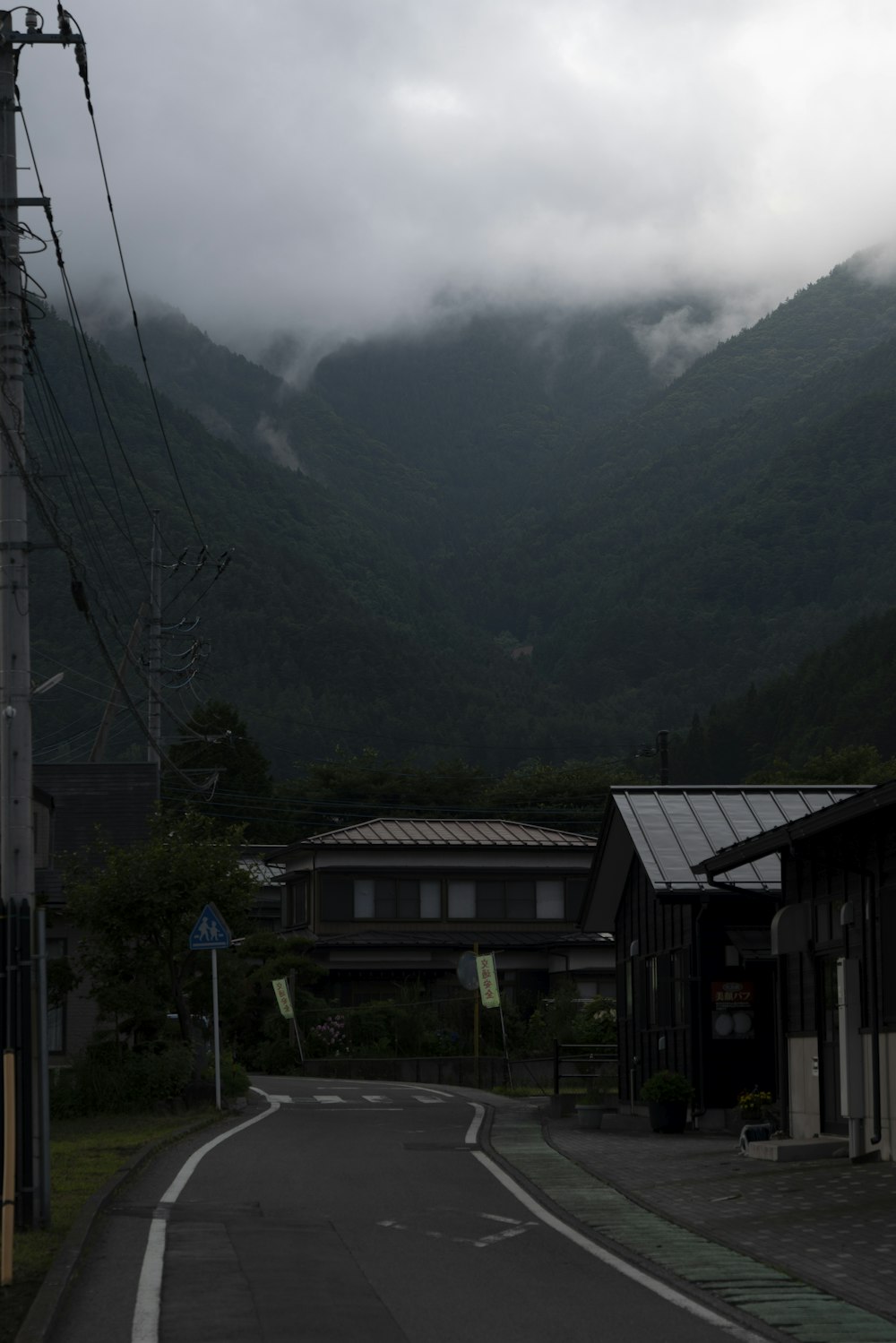 brown wooden house near green mountains during daytime