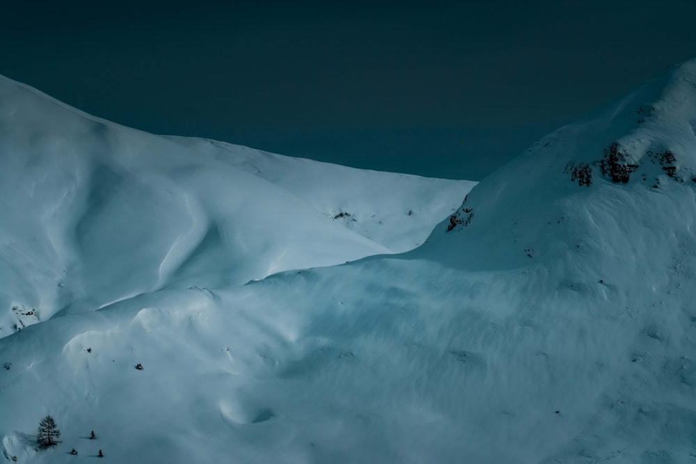 pessoa andando na montanha coberta de neve durante o dia