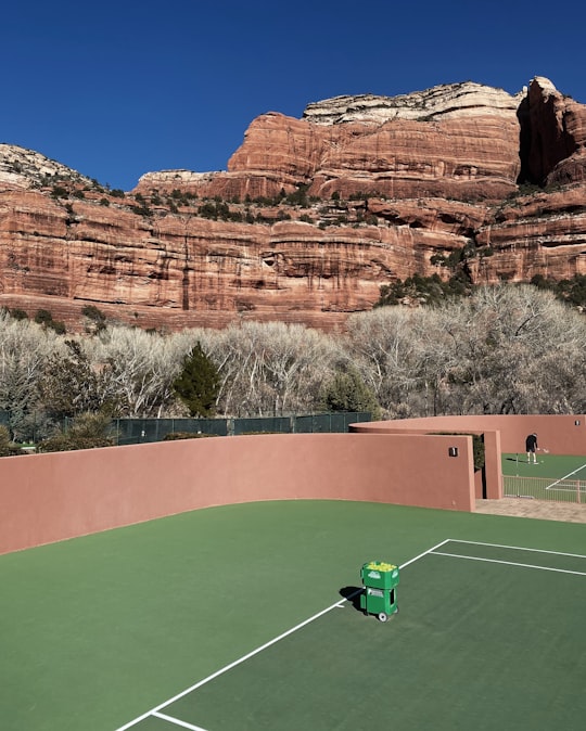 green golf course near brown rock formation during daytime in Sedona United States