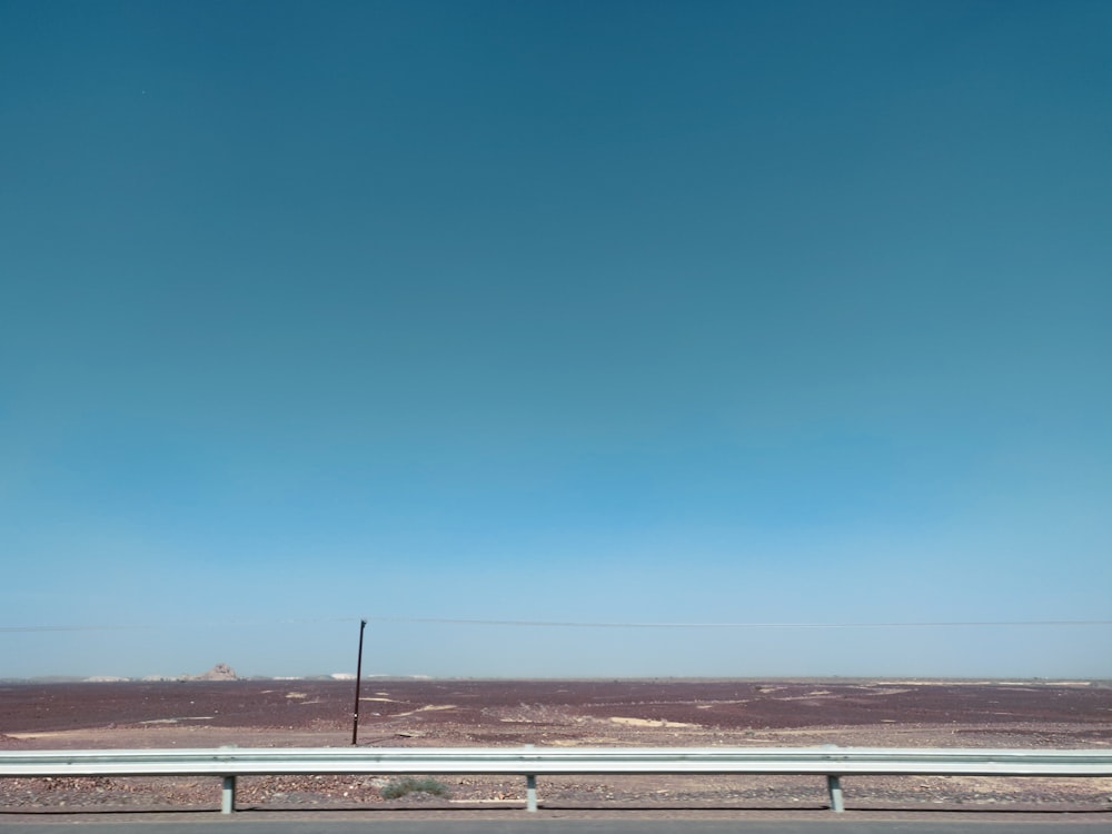 strada marrone e bianca sotto il cielo blu durante il giorno