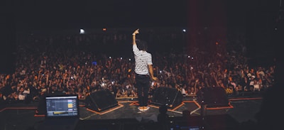man in white and black striped shirt standing on stage