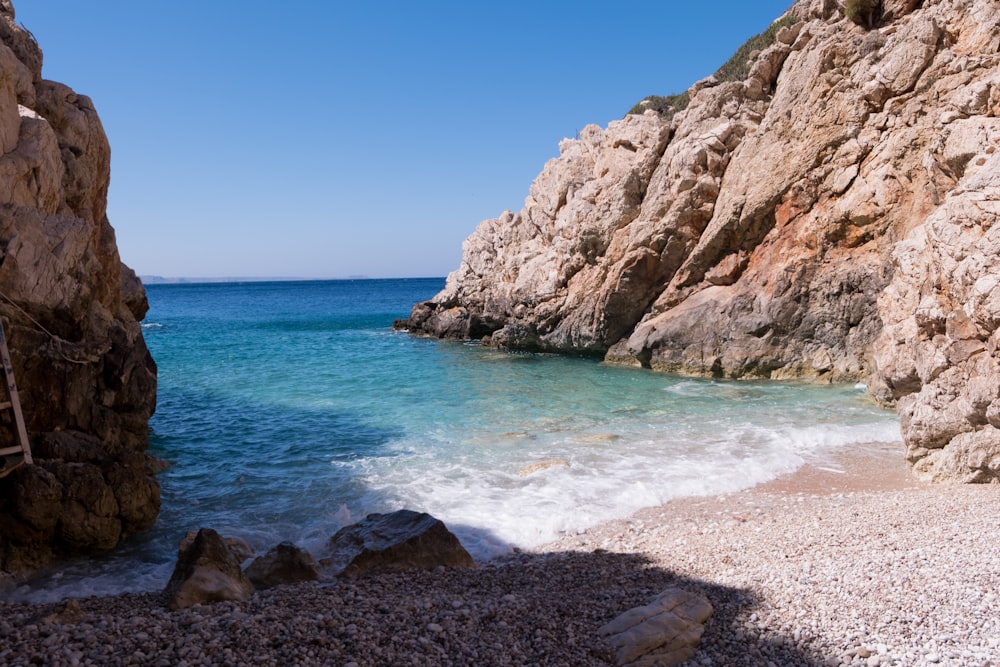 brown rock formation on blue sea under blue sky during daytime