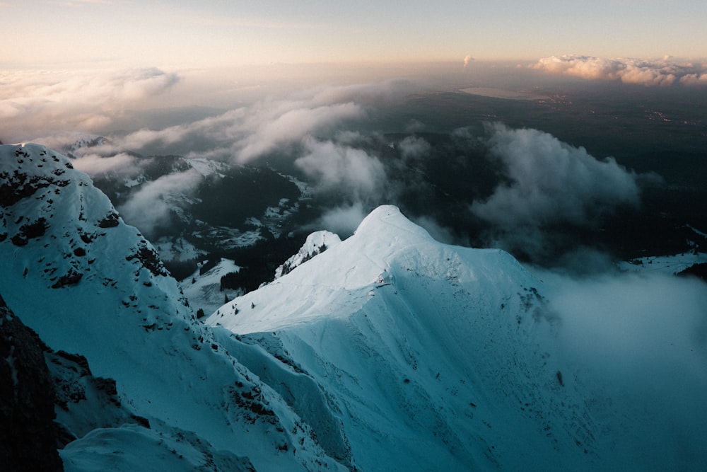 snow covered mountain under white clouds during daytime