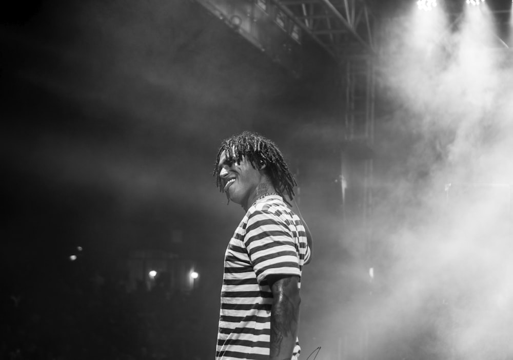 man in striped shirt standing in front of stage