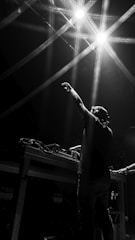 man in black t-shirt raising his hands