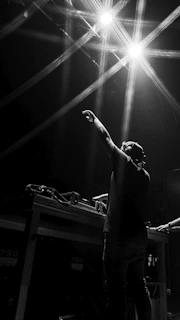 man in black t-shirt raising his hands