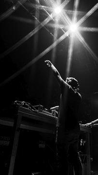man in black t-shirt raising his hands
