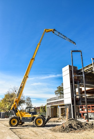 yellow crane near white building during daytime