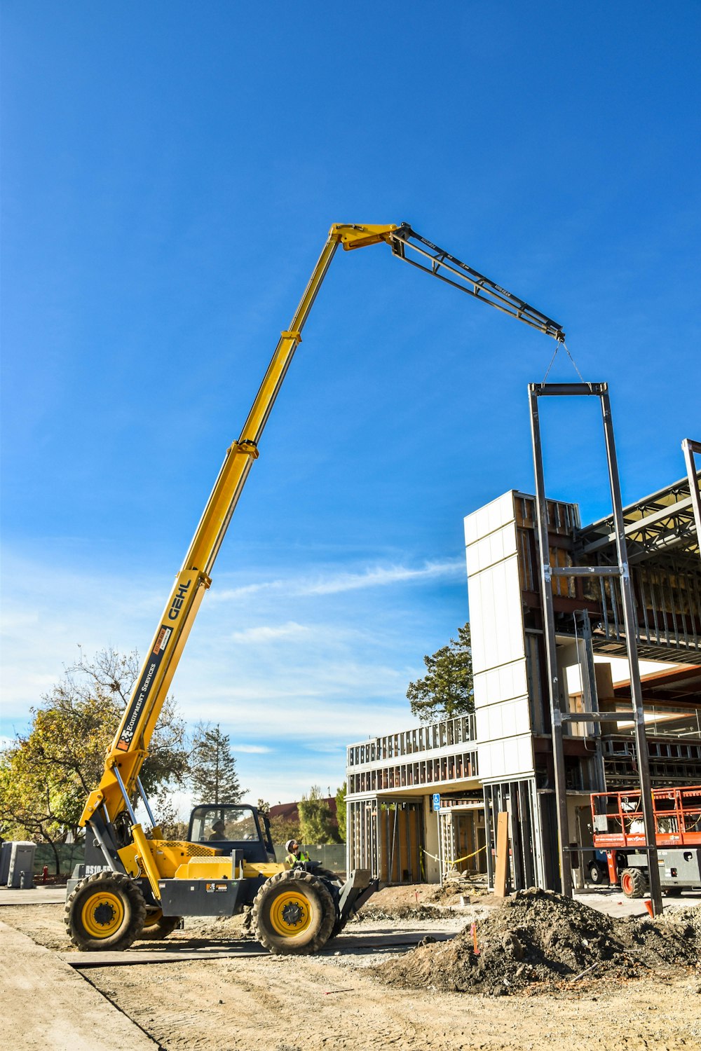 yellow crane near white building during daytime