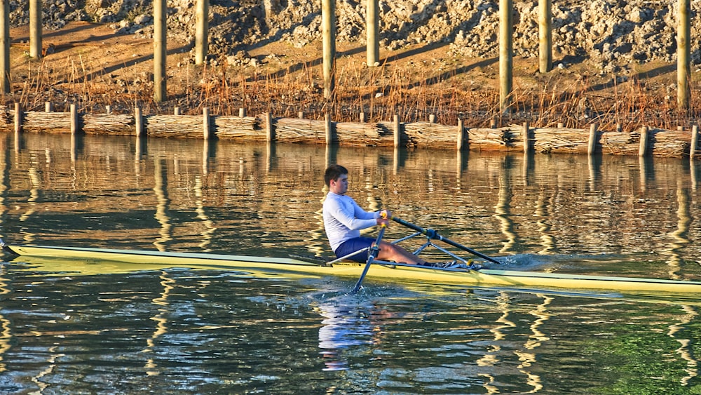 man in white shirt riding yellow kayak on river during daytime