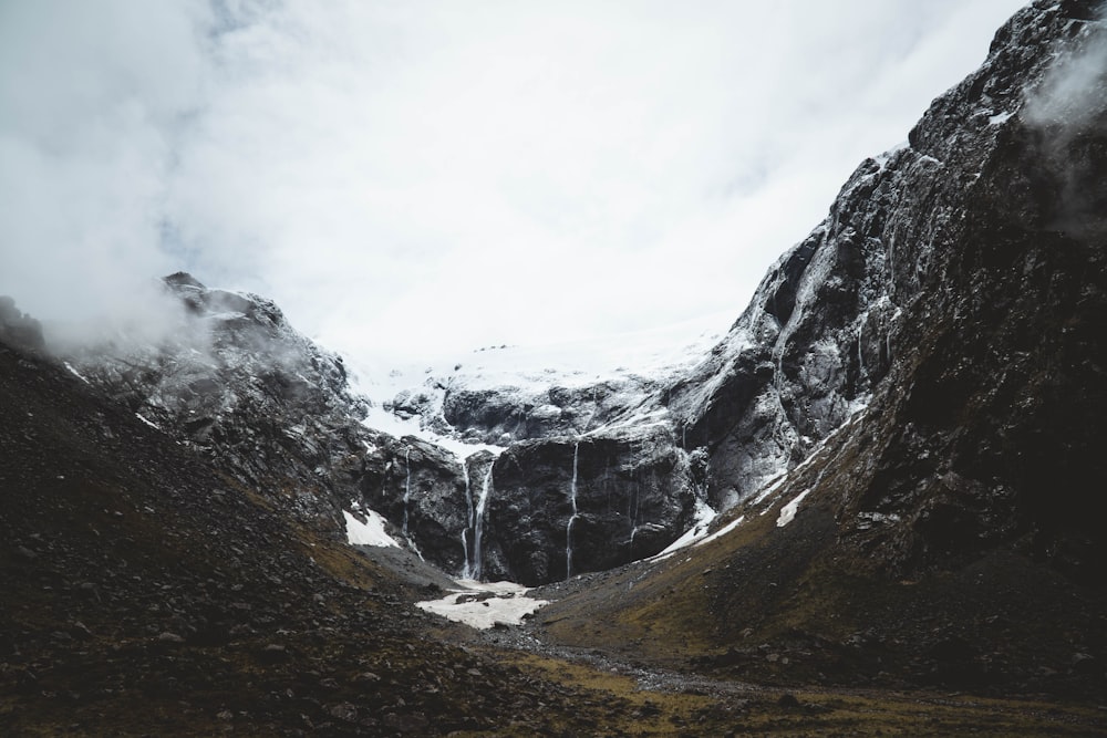 gray rocky mountain under white cloudy sky during daytime