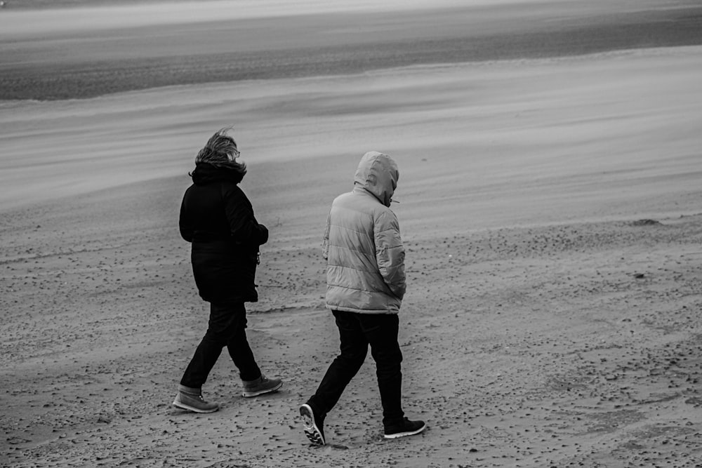 man and woman walking on the beach