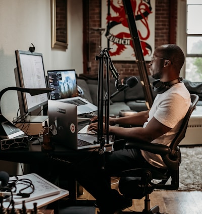 man in white t-shirt sitting on black office rolling chair