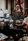 man in white t-shirt sitting on black office rolling chair