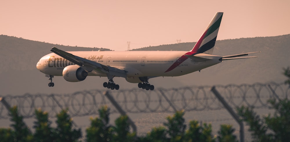 white and red air plane in the sky during daytime