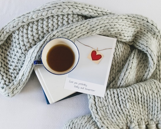 A cozy, warm-toned photo of a handwritten love note beside a cup of coffee.