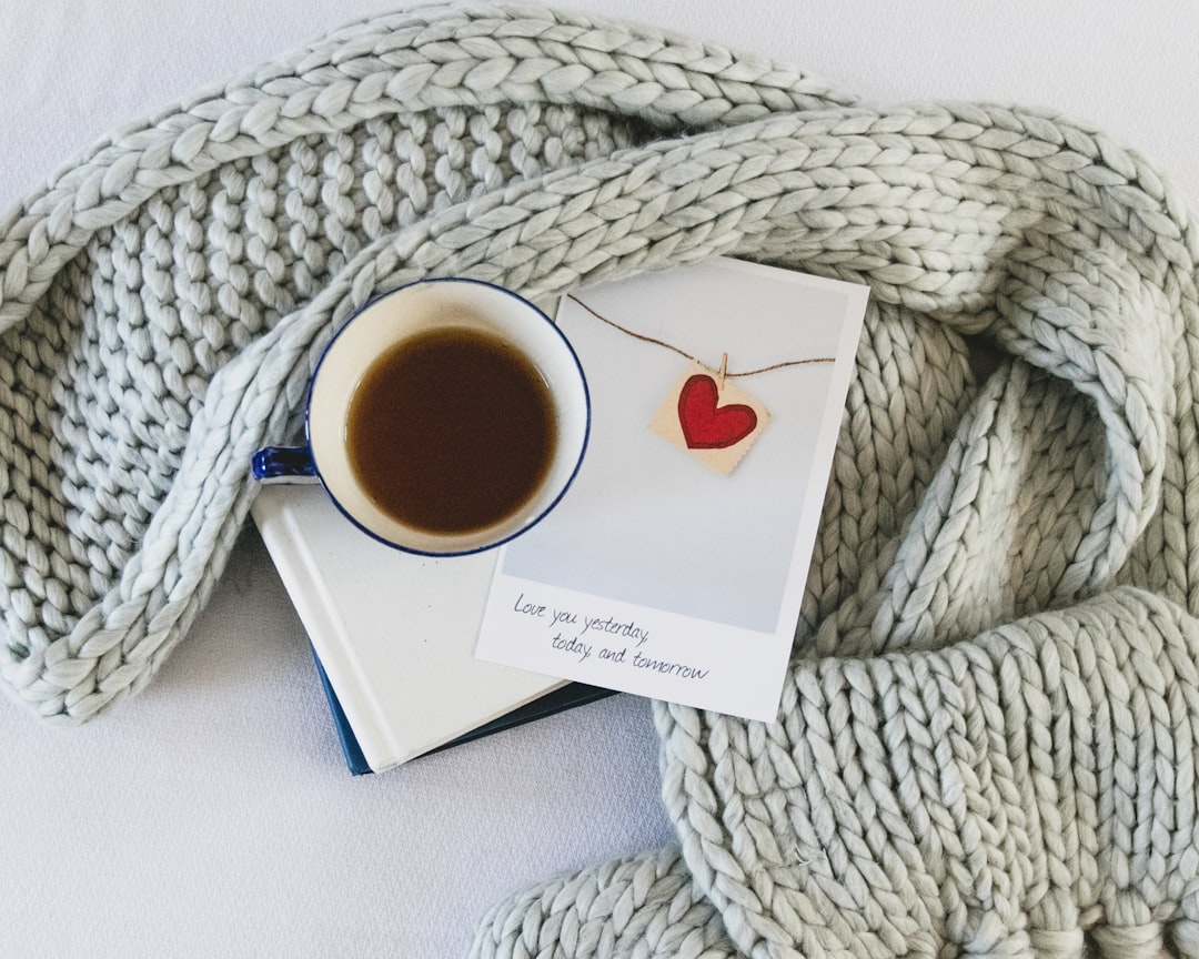 white ceramic mug on white knit textile