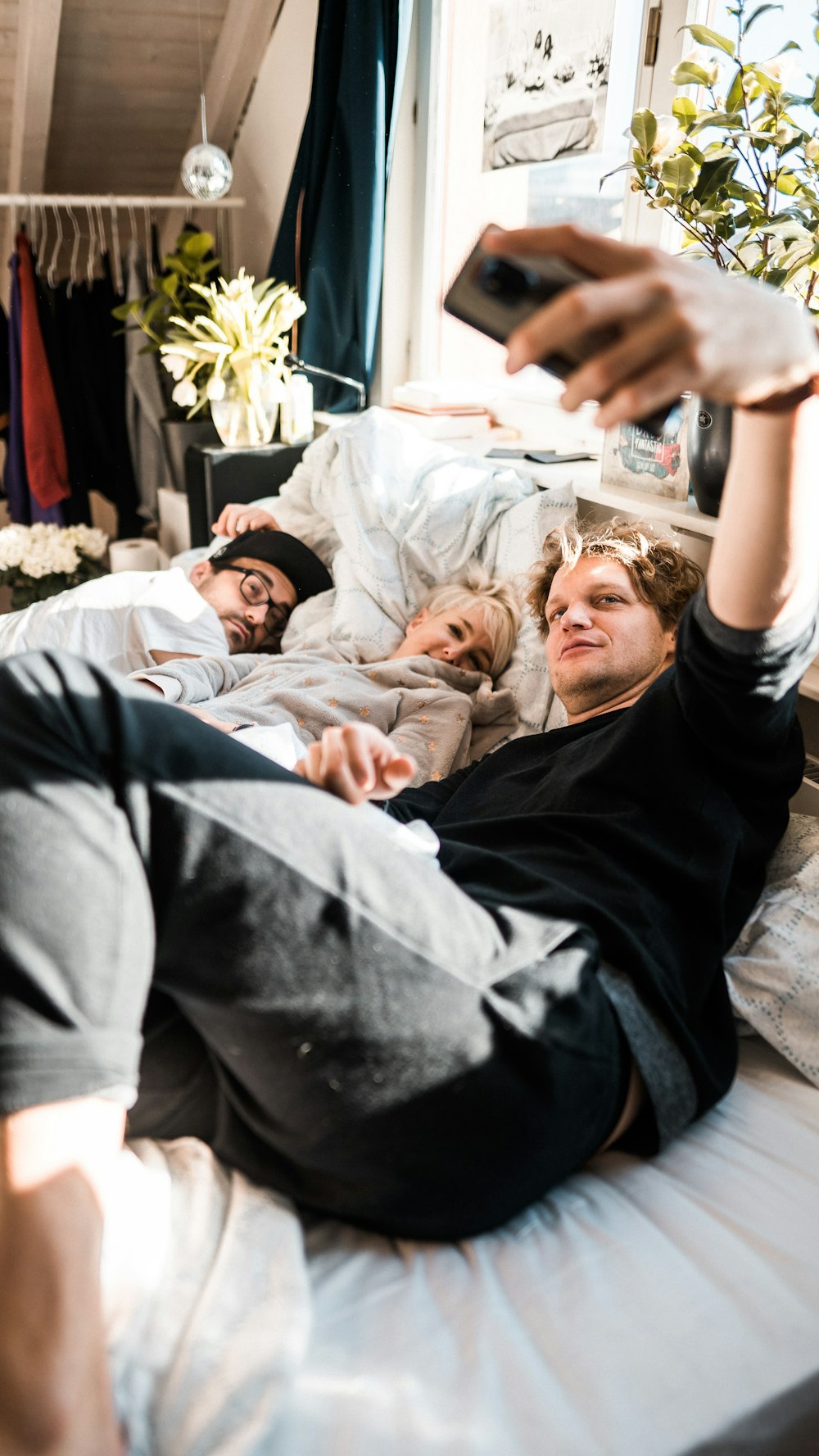 homme en t-shirt noir couché sur le lit