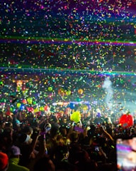 Fans in a conga line during a tidal rave show, vibrant colors and smiles everywhere.