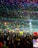 A joyful crowd dancing at a vibrant music festival under colorful lights.