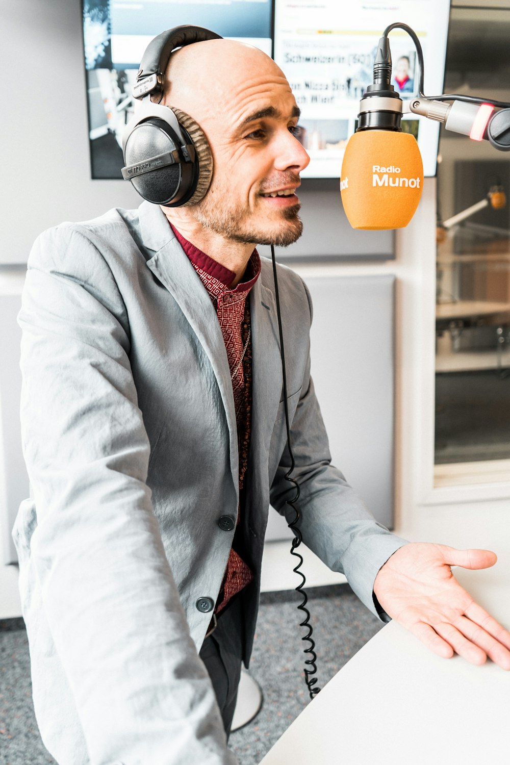 man in gray suit jacket wearing black headphones