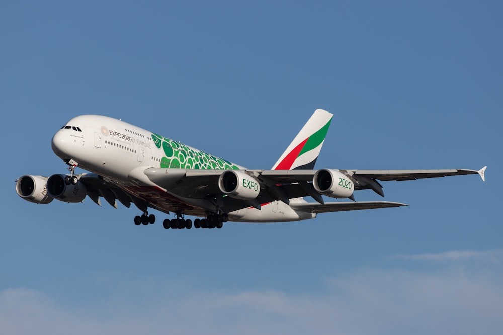 white and green air plane flying during daytime