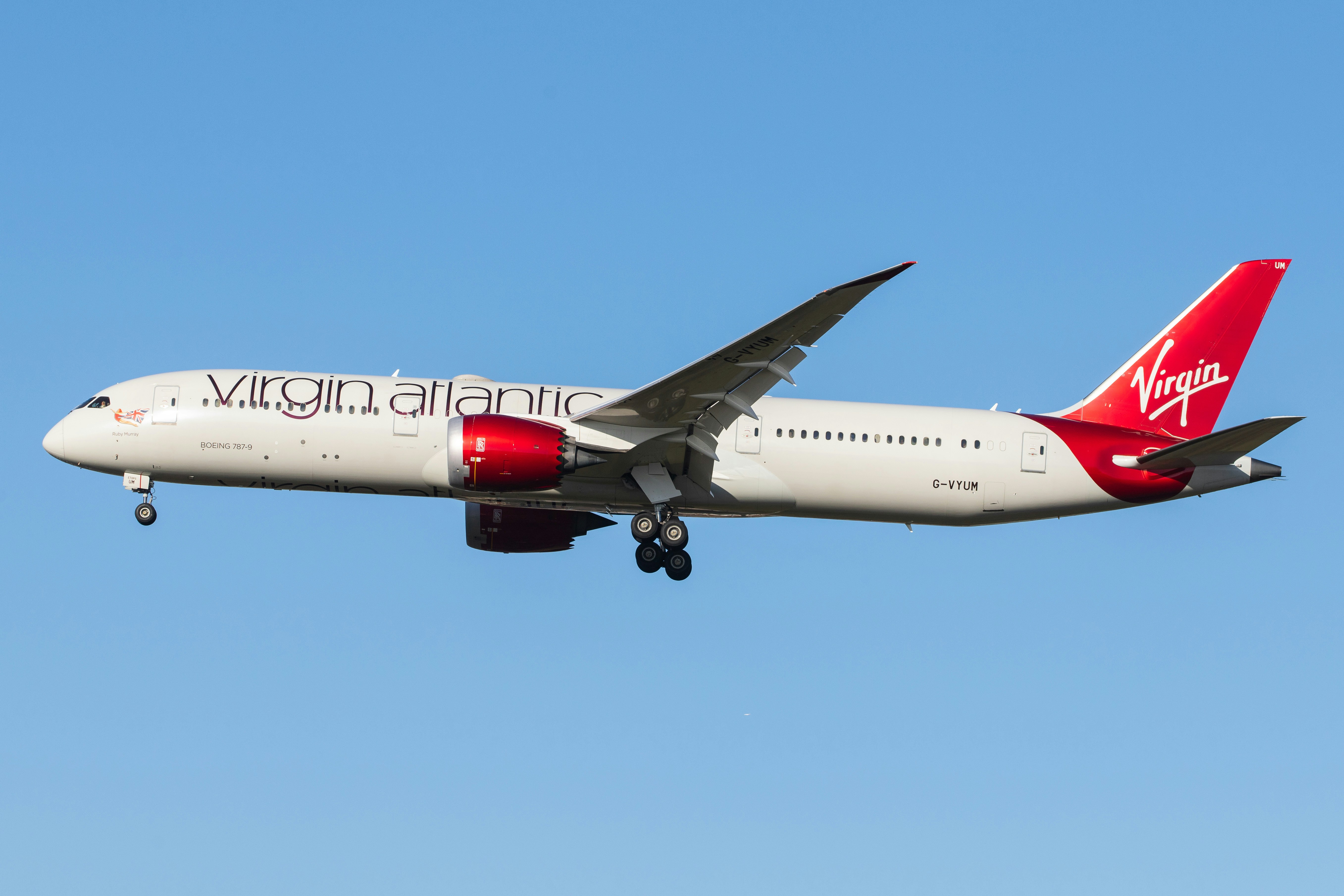 white and red air plane in mid air during daytime