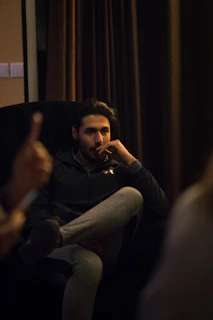 man in black jacket sitting on couch