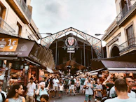 A lively market square in Barcelona filled with people and vibrant street art.