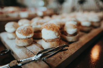 Close-up of artisanal petit fours arranged on a rustic wooden board with delicate icing details