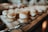 Small pastries filled with cream are arranged on a wooden board. They are dusted with powdered sugar, creating an inviting and delicious presentation. In the foreground, a metal serving utensil is visible.