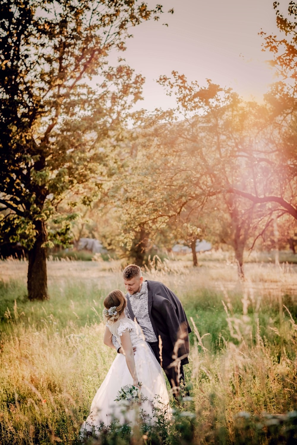 man and woman walking on green grass field during daytime