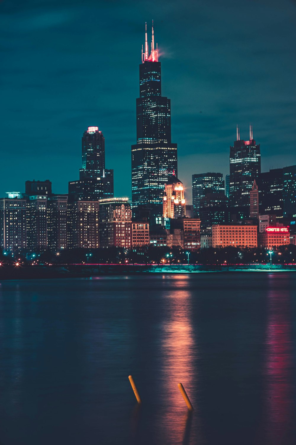 city skyline across body of water during night time