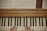 A pair of hands positioned on a piano keyboard, with visible sheet music placed above on a wooden piano surface.