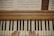 A pair of hands positioned on a piano keyboard, with visible sheet music placed above on a wooden piano surface.