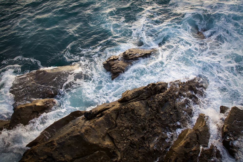 brown rock formation beside blue sea during daytime