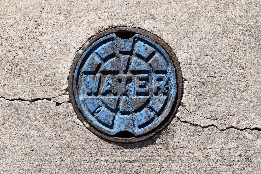 a manhole cover on a sidewalk with the word repair painted on it