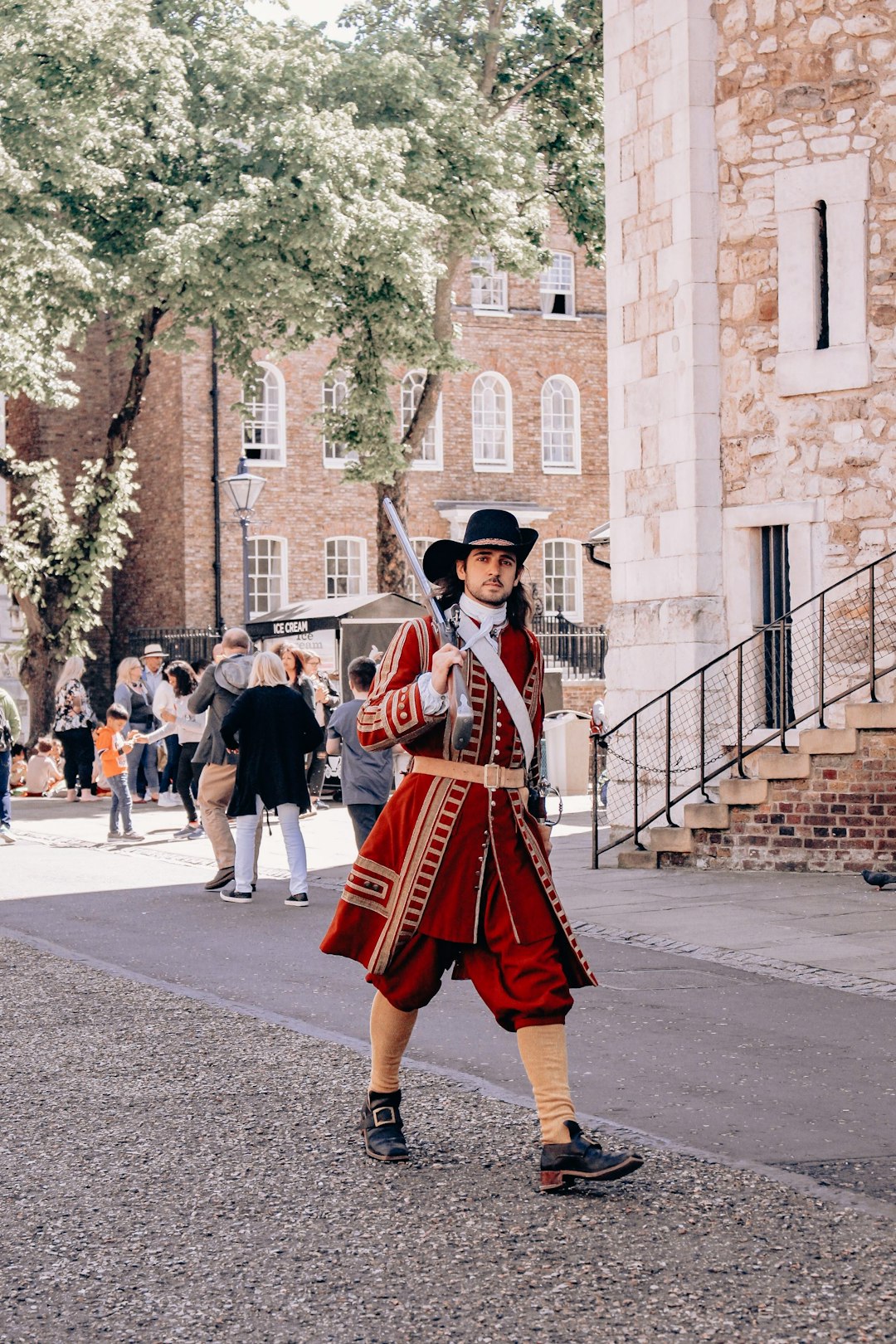 people in red and black uniform walking on street during daytime