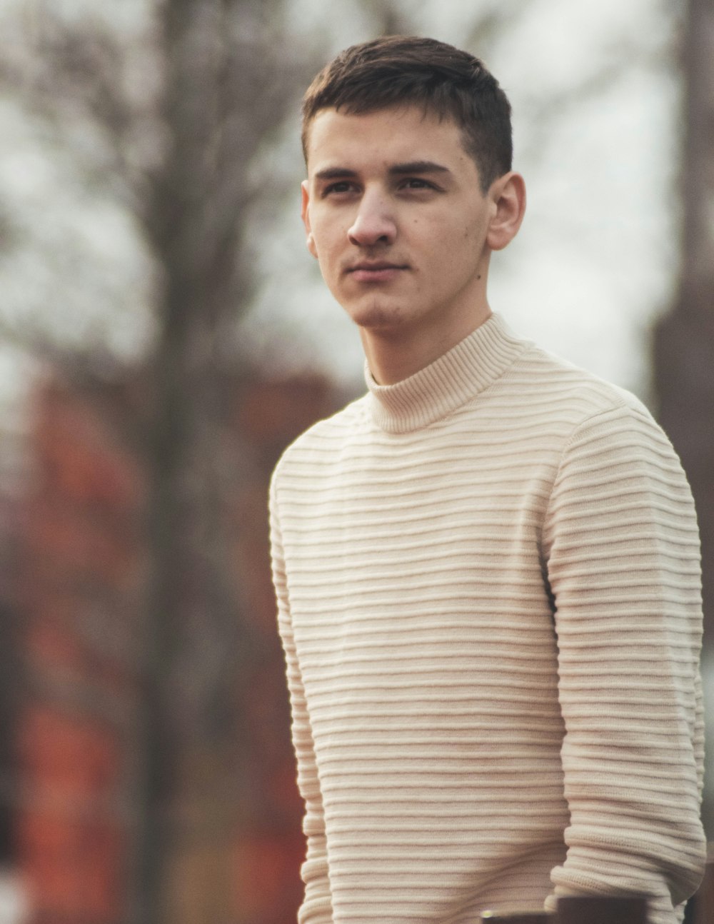 homme en pull à col roulé blanc